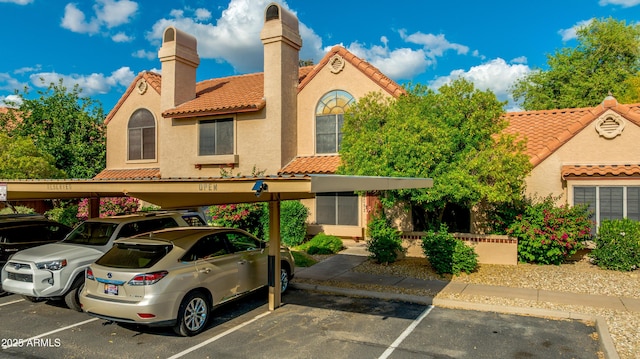 4901 E Kelton Ln Unit 1052, Scottsdale, AZ 85254 - view of front of house featuring covered and uncovered parking, a tiled roof, and stucco siding