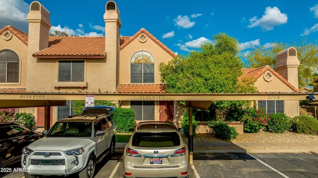 4901 E Kelton Ln Unit 1052, Scottsdale, AZ 85254 - view of front of home featuring covered parking, a tile roof, and stucco siding