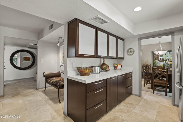 7714 N 17th Pl, Phoenix, AZ 85020 - kitchen with light countertops, baseboards, dark brown cabinets, and visible vents