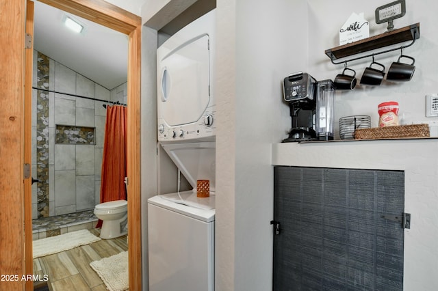 clothes washing area featuring stacked washer and clothes dryer