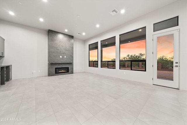 unfurnished living room featuring a tile fireplace