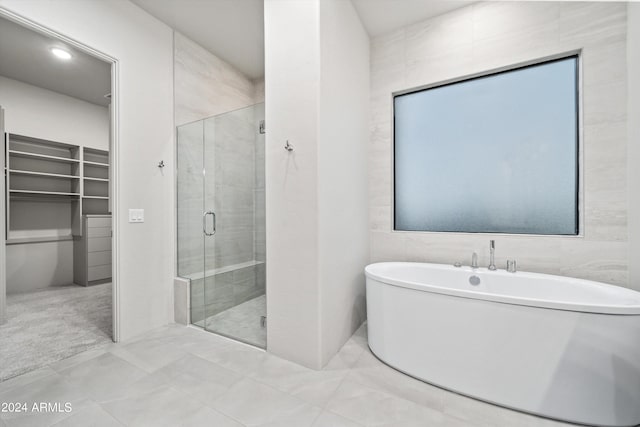 bathroom featuring tile walls, shower with separate bathtub, and tile patterned floors