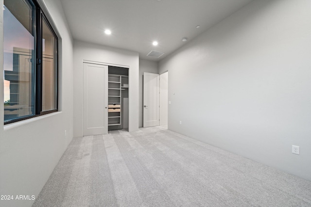 interior space with a closet and light colored carpet