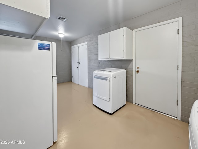 clothes washing area with cabinets