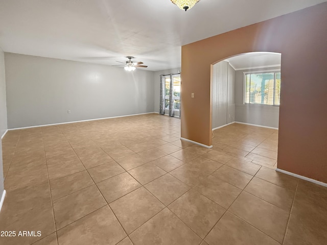 tiled empty room with ceiling fan and a wealth of natural light