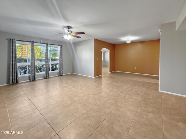 spare room with ceiling fan and light tile patterned flooring