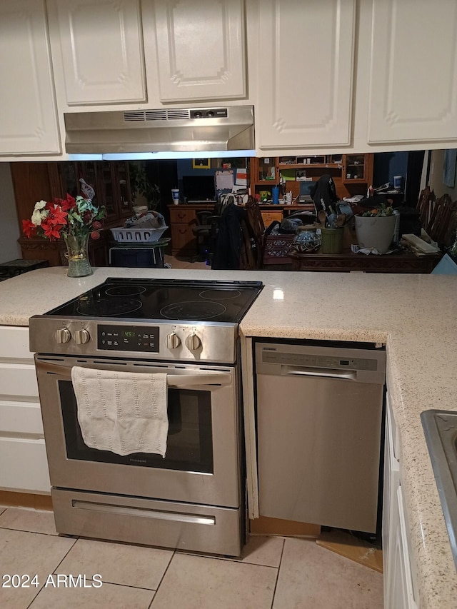 kitchen featuring appliances with stainless steel finishes, white cabinetry, and range hood