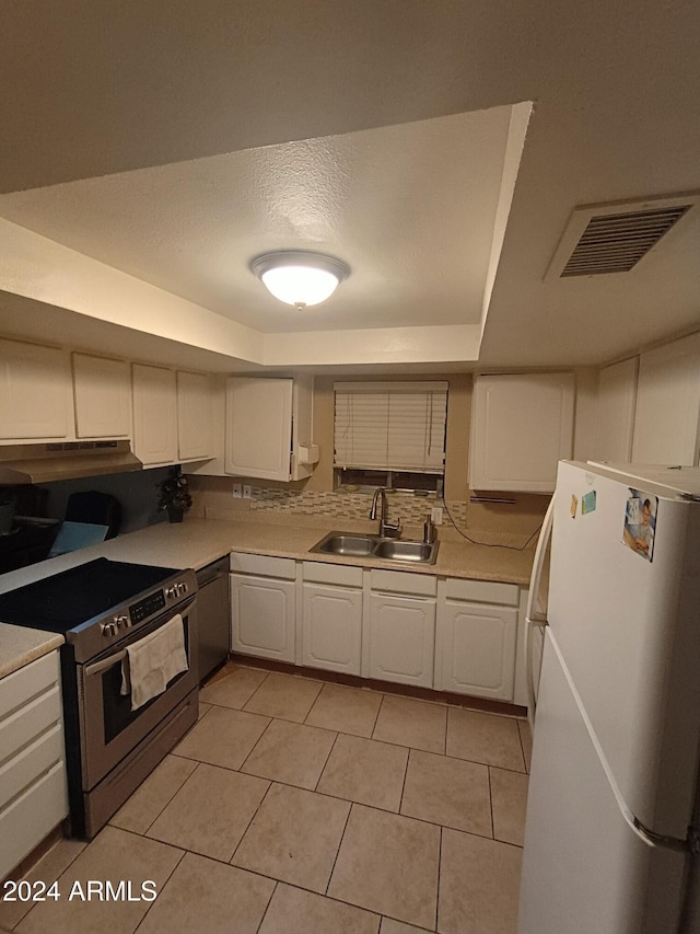 kitchen with sink, white refrigerator, stainless steel electric range, white cabinets, and exhaust hood