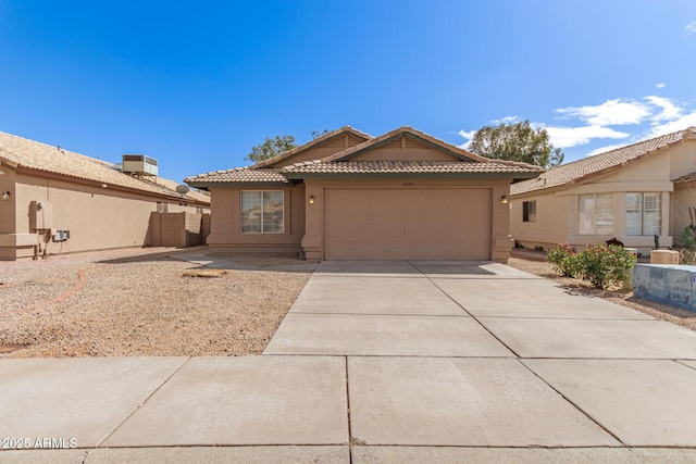 view of front of home featuring a tile roof, an attached garage, driveway, and stucco siding