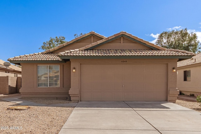 view of front of home with a tile roof, stucco siding, an attached garage, and concrete driveway