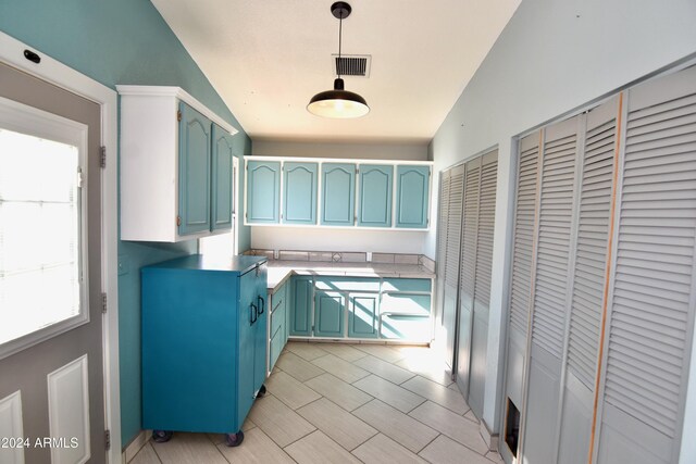 kitchen with plenty of natural light, pendant lighting, and vaulted ceiling