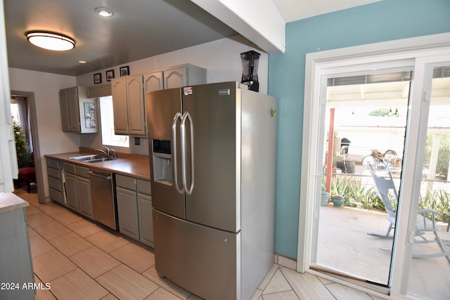 kitchen with light tile patterned flooring, sink, and stainless steel appliances