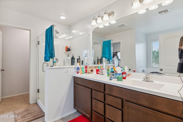 bathroom with tile patterned flooring, vanity, and a shower with shower door