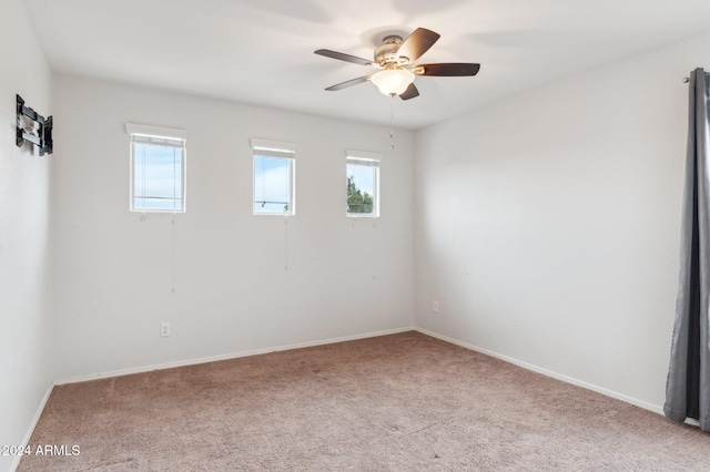 spare room featuring plenty of natural light, ceiling fan, and light carpet