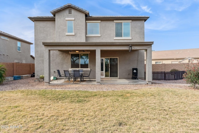 back of house with a patio and a lawn