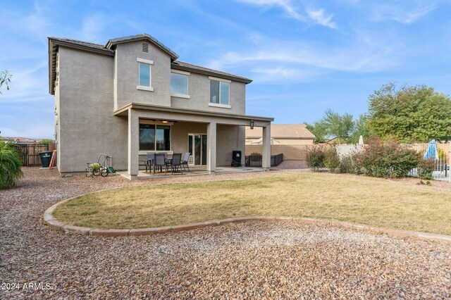 rear view of house with a yard and a patio