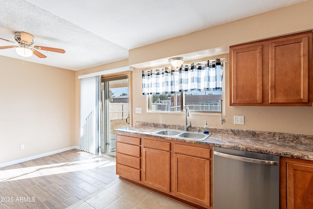 kitchen featuring dishwasher, sink, ceiling fan, a textured ceiling, and light hardwood / wood-style floors