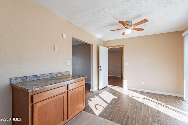 kitchen featuring ceiling fan, light hardwood / wood-style flooring, and a textured ceiling