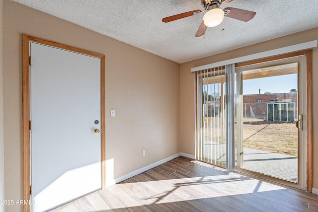 doorway to outside featuring ceiling fan and a textured ceiling