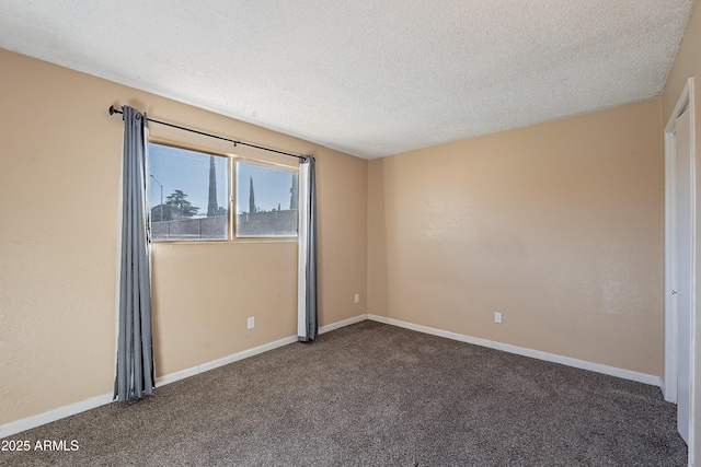 unfurnished room featuring dark carpet and a textured ceiling