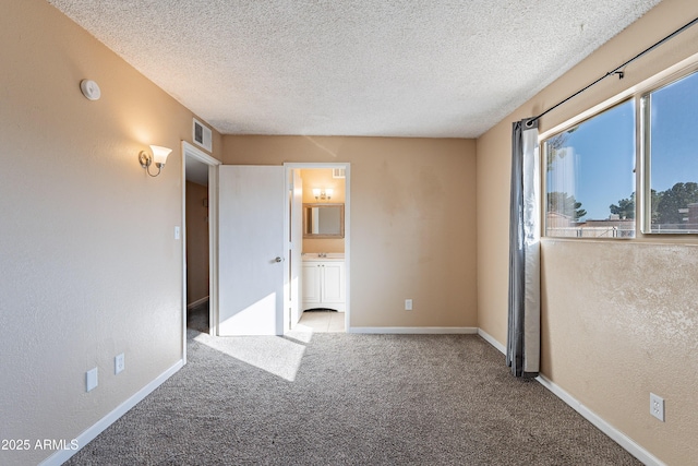 spare room with carpet floors and a textured ceiling