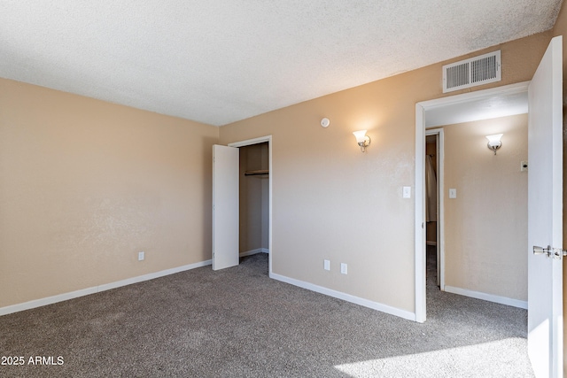 unfurnished bedroom featuring a textured ceiling and carpet floors