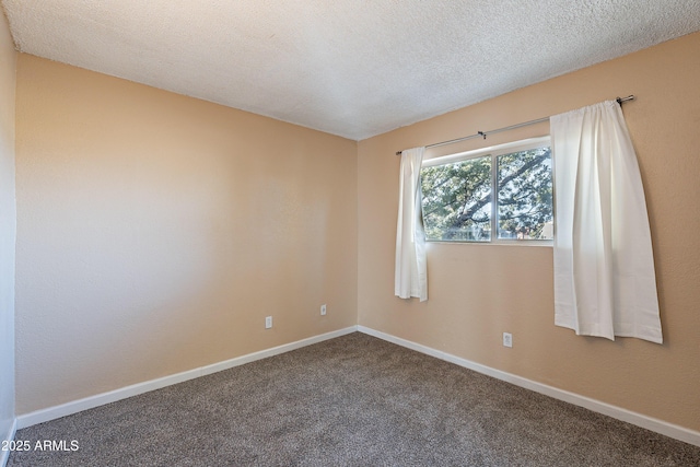 carpeted empty room featuring a textured ceiling