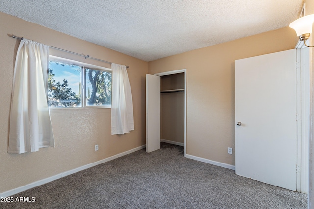 unfurnished bedroom featuring carpet flooring, a textured ceiling, and a closet