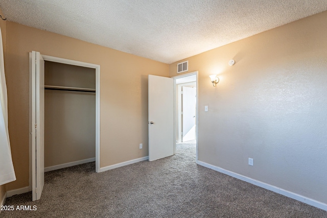 unfurnished bedroom featuring a closet, carpet, and a textured ceiling