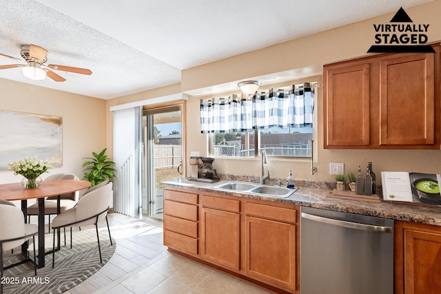 kitchen with a textured ceiling, ceiling fan, sink, light tile patterned floors, and dishwasher