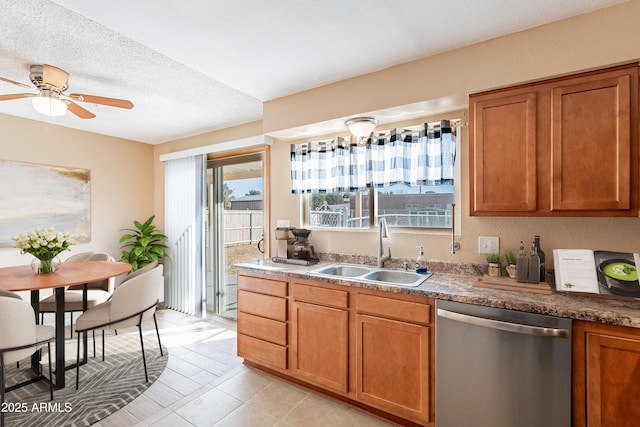 kitchen with ceiling fan, sink, stainless steel dishwasher, a textured ceiling, and light tile patterned flooring