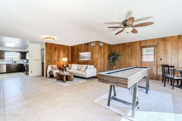 playroom featuring sink, ceiling fan, and wood walls