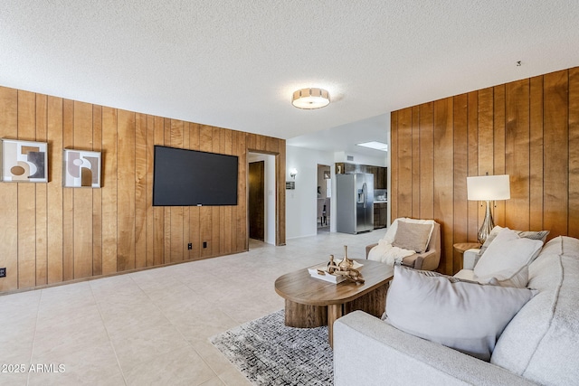 living room with a textured ceiling and wood walls