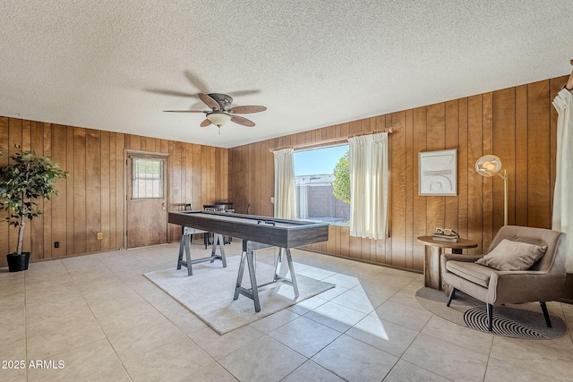 playroom with ceiling fan, a textured ceiling, and light tile patterned flooring