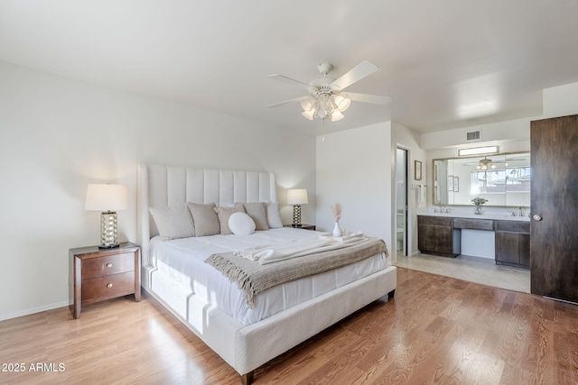 bedroom featuring ceiling fan, ensuite bathroom, and light wood-type flooring