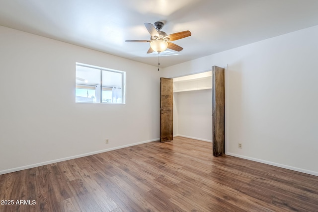 empty room with hardwood / wood-style flooring and ceiling fan