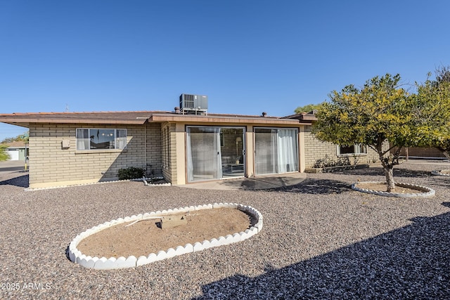 back of property with central AC unit and a patio area