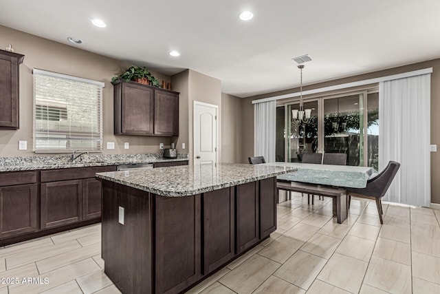 1723 N Hillcrest, Mesa, AZ 85201 - kitchen featuring dark brown cabinets, light stone countertops, a center island, recessed lighting, and pendant lighting
