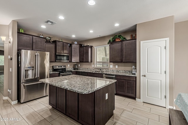 1723 N Hillcrest, Mesa, AZ 85201 - kitchen with appliances with stainless steel finishes, dark brown cabinetry, light stone counters, a kitchen island, and recessed lighting