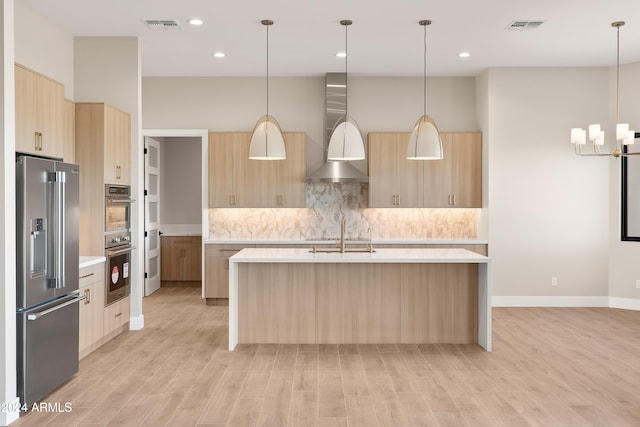 kitchen featuring light hardwood / wood-style flooring, hanging light fixtures, and stainless steel appliances