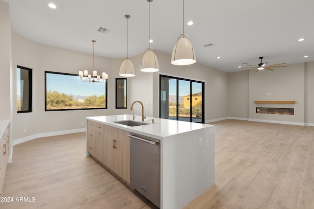 kitchen with sink, dishwasher, an island with sink, decorative light fixtures, and light hardwood / wood-style flooring