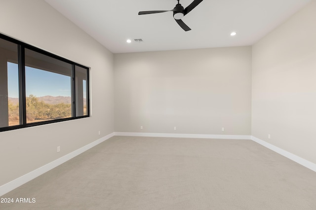 unfurnished room featuring light carpet and ceiling fan