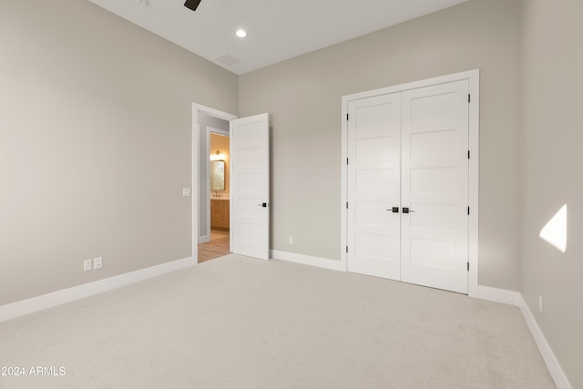 unfurnished bedroom with a closet, ceiling fan, and light colored carpet