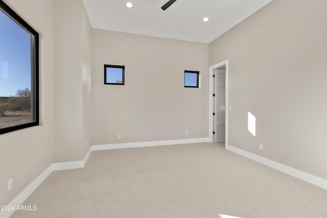 empty room with light colored carpet and ceiling fan