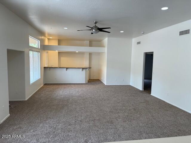 unfurnished living room with visible vents, baseboards, recessed lighting, carpet, and a ceiling fan