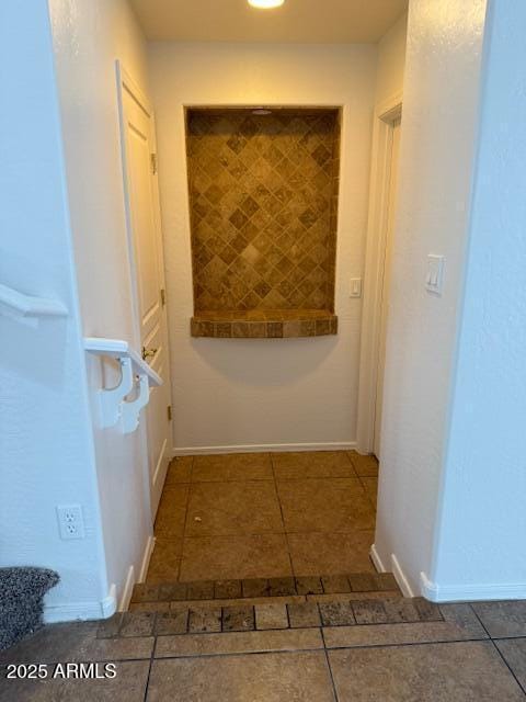 hall featuring tile patterned flooring and baseboards