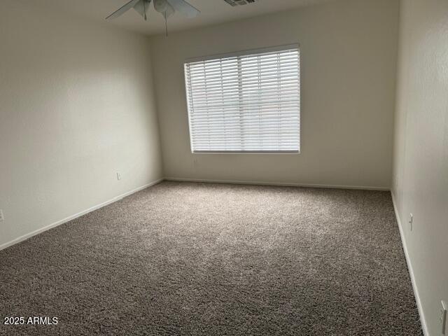 unfurnished room with baseboards, ceiling fan, and carpet floors