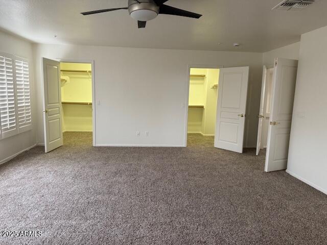 unfurnished bedroom with a closet, visible vents, and a spacious closet