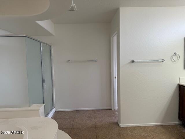full bath featuring baseboards, a stall shower, tile patterned flooring, and vanity