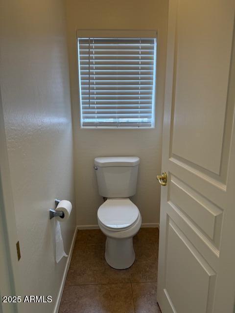 bathroom with tile patterned floors, toilet, and baseboards